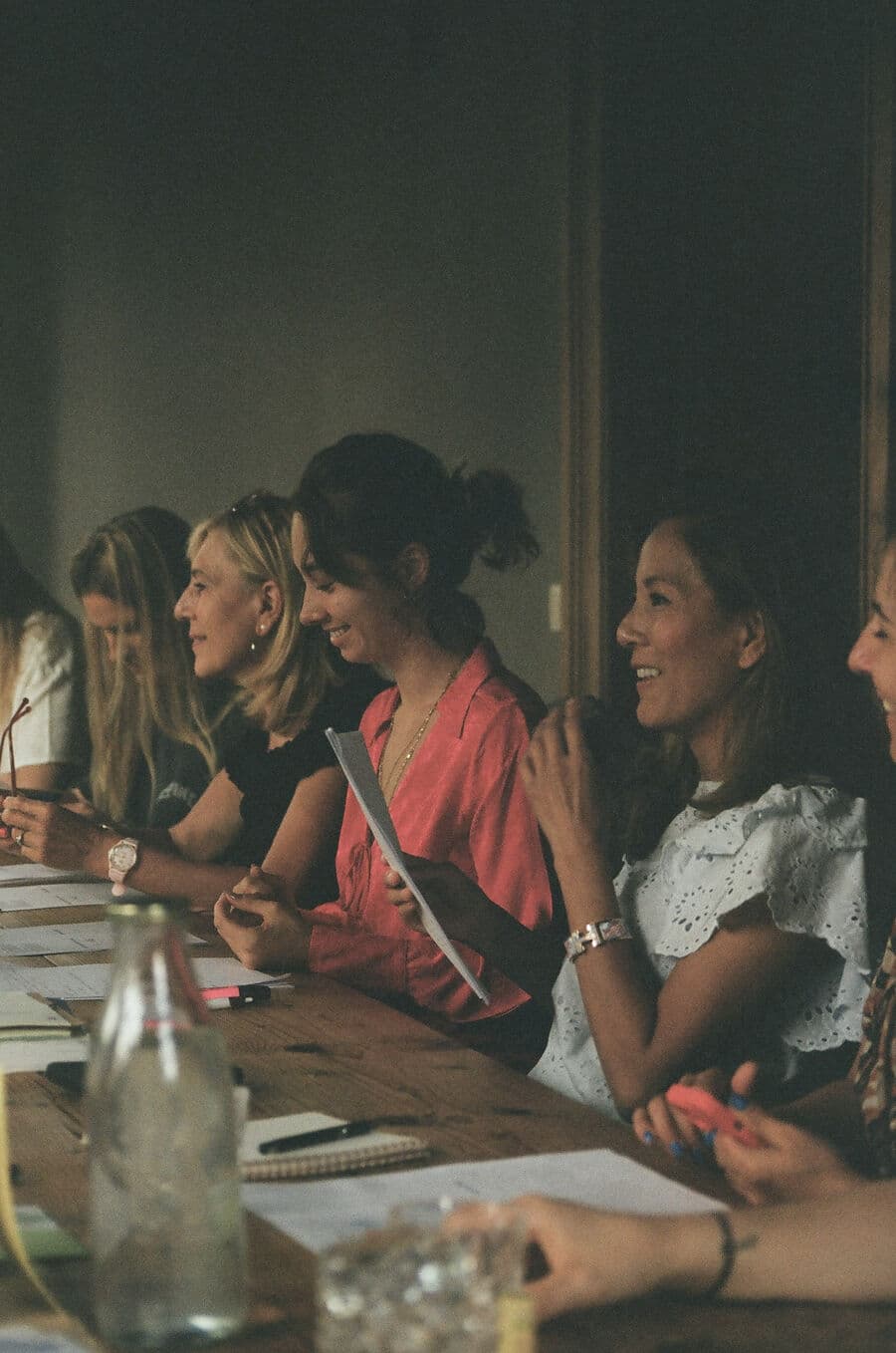 Des invitées qui sourient autour de la table pendant l'atelier
