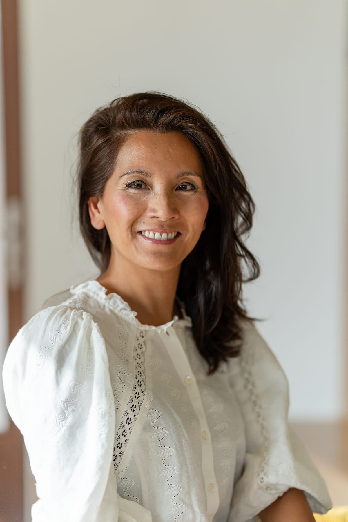 Marie-Ange smiling, in a white blouse