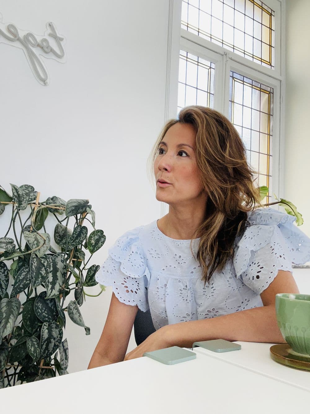 Marie-Ange at a table, looking out of the window