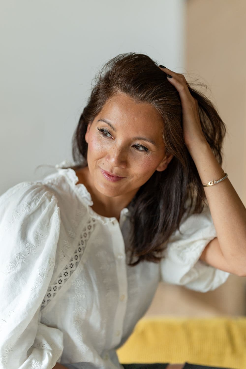 Marie-Ange brushing her hair back, smiling
